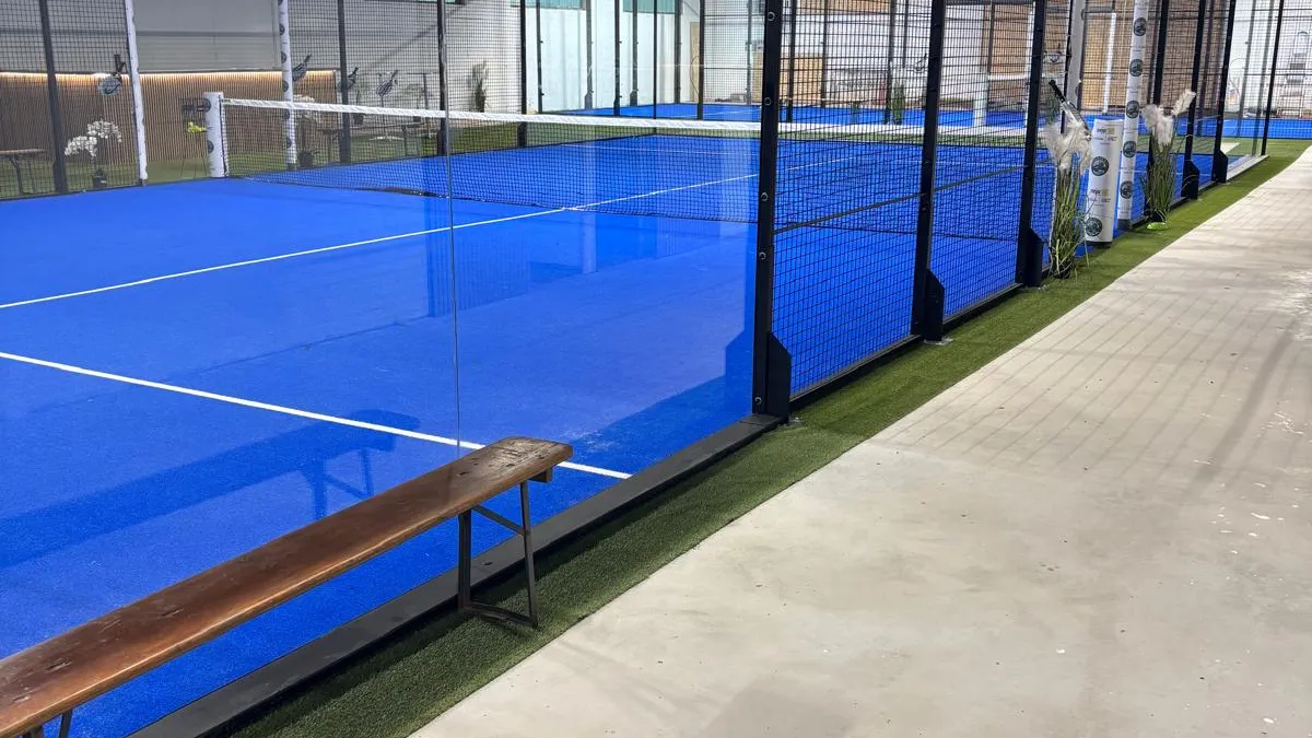 Doppelcourt mit Glaswand und blauem Belag in der Halle von Padeln am Berg
