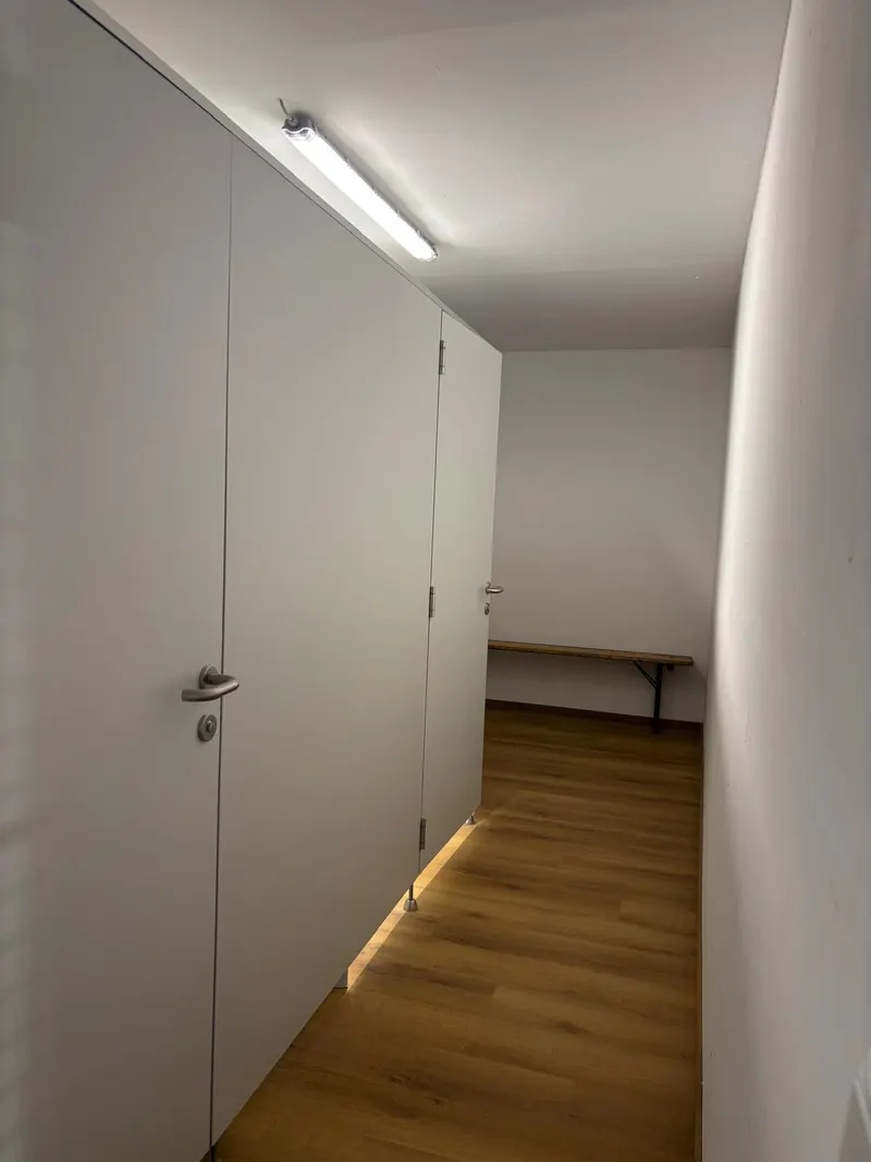 Gang im Umkleidebereich mit WC-Kabinen und Sitzbank